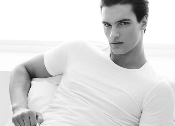 Black and white photo: person in white t-shirt, serious expression.