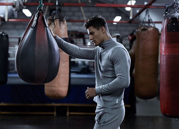 Man in loungewear focuses in dimly lit gym.