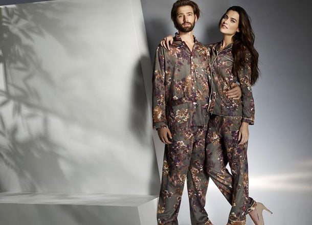 Couple in matching floral pajamas, chic loungewear, minimalist backdrop.