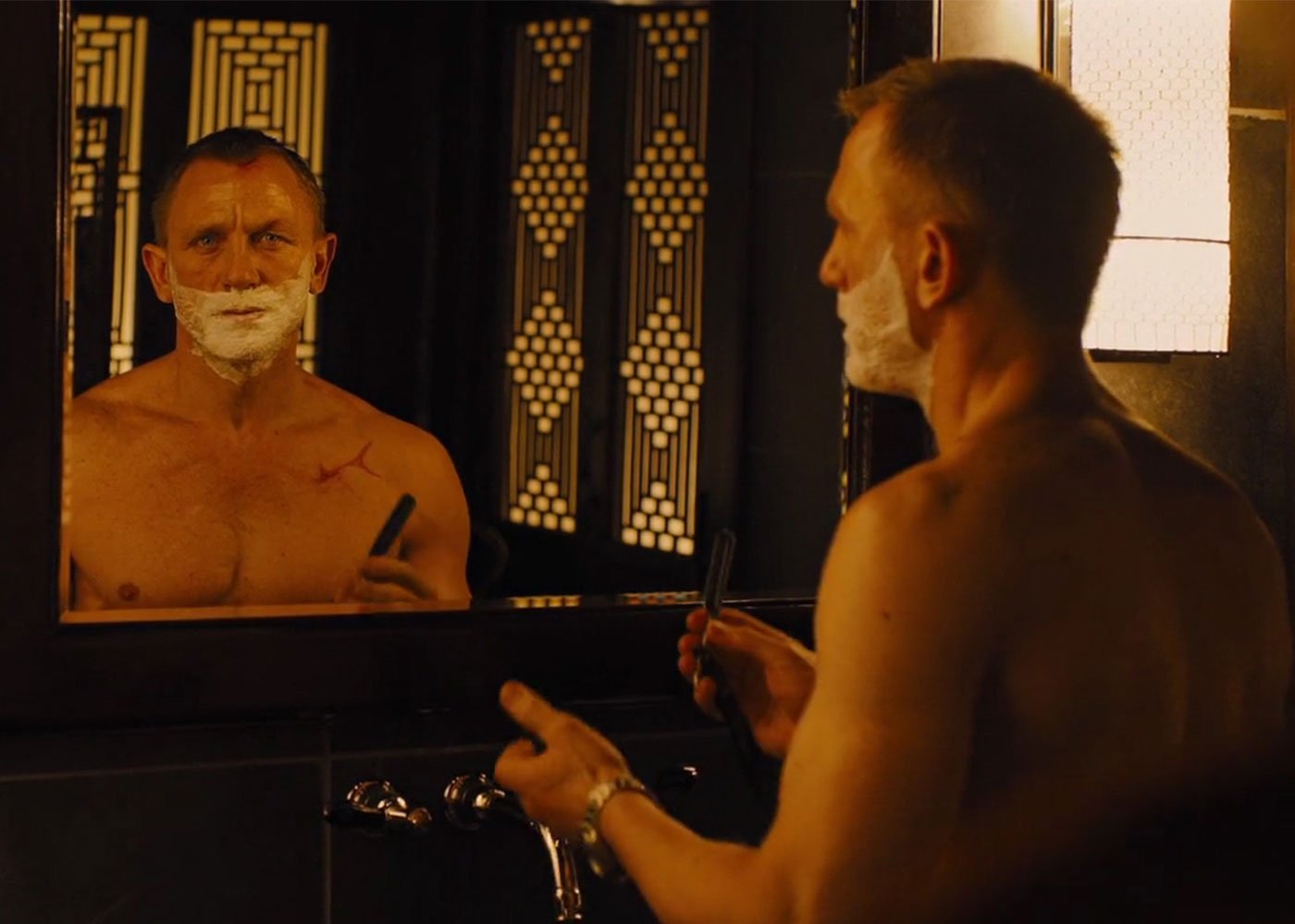 Shirtless man with razor, avoiding burns.