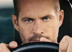 A focused person grips Porsche's steering wheel.