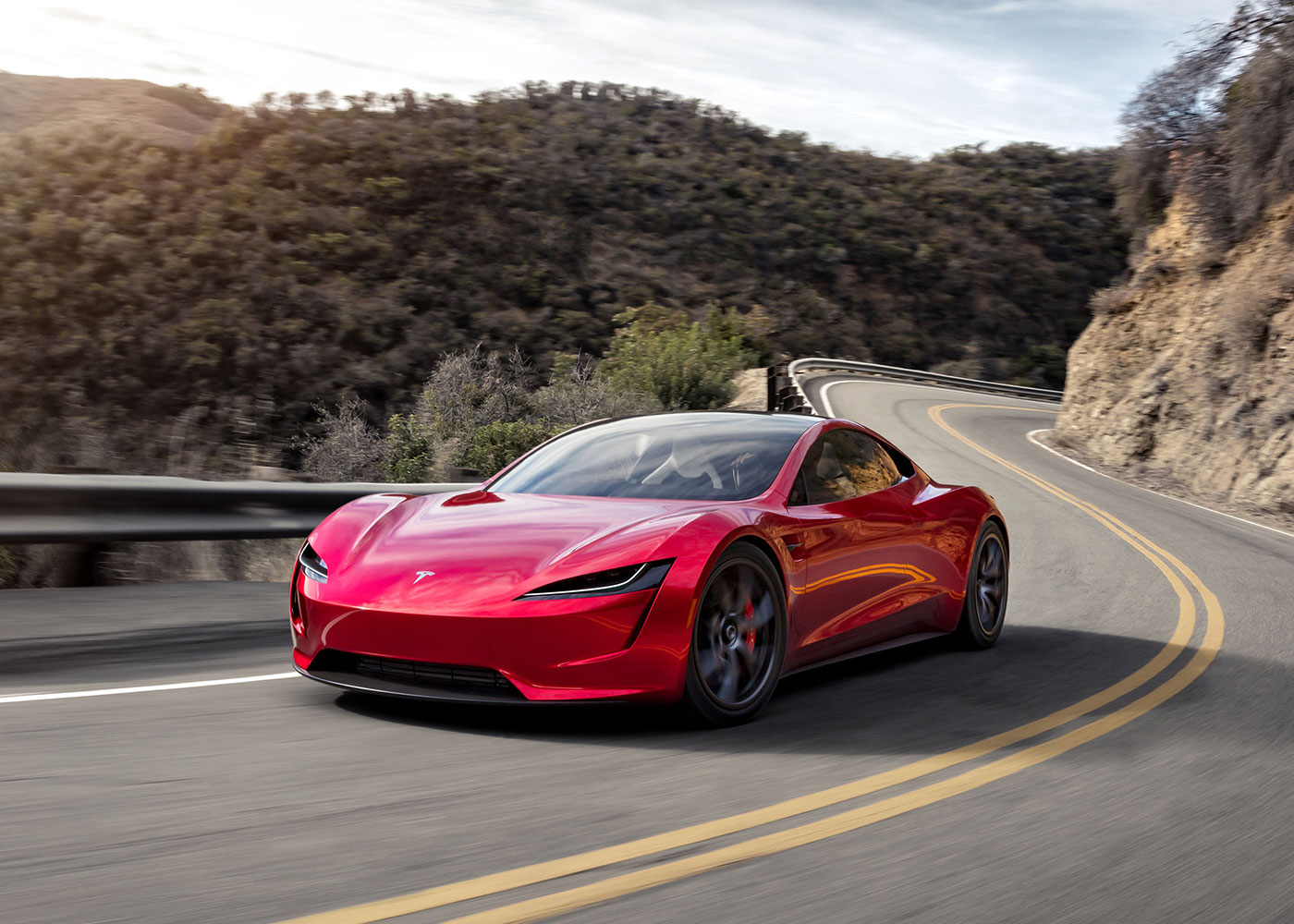 Tesla sports car navigates winding mountain road.
