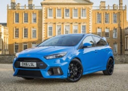Blue Ford Focus RS parked by historic building.