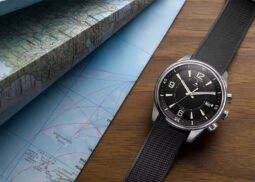 Jaeger-LeCoultre watch on wood beside map.