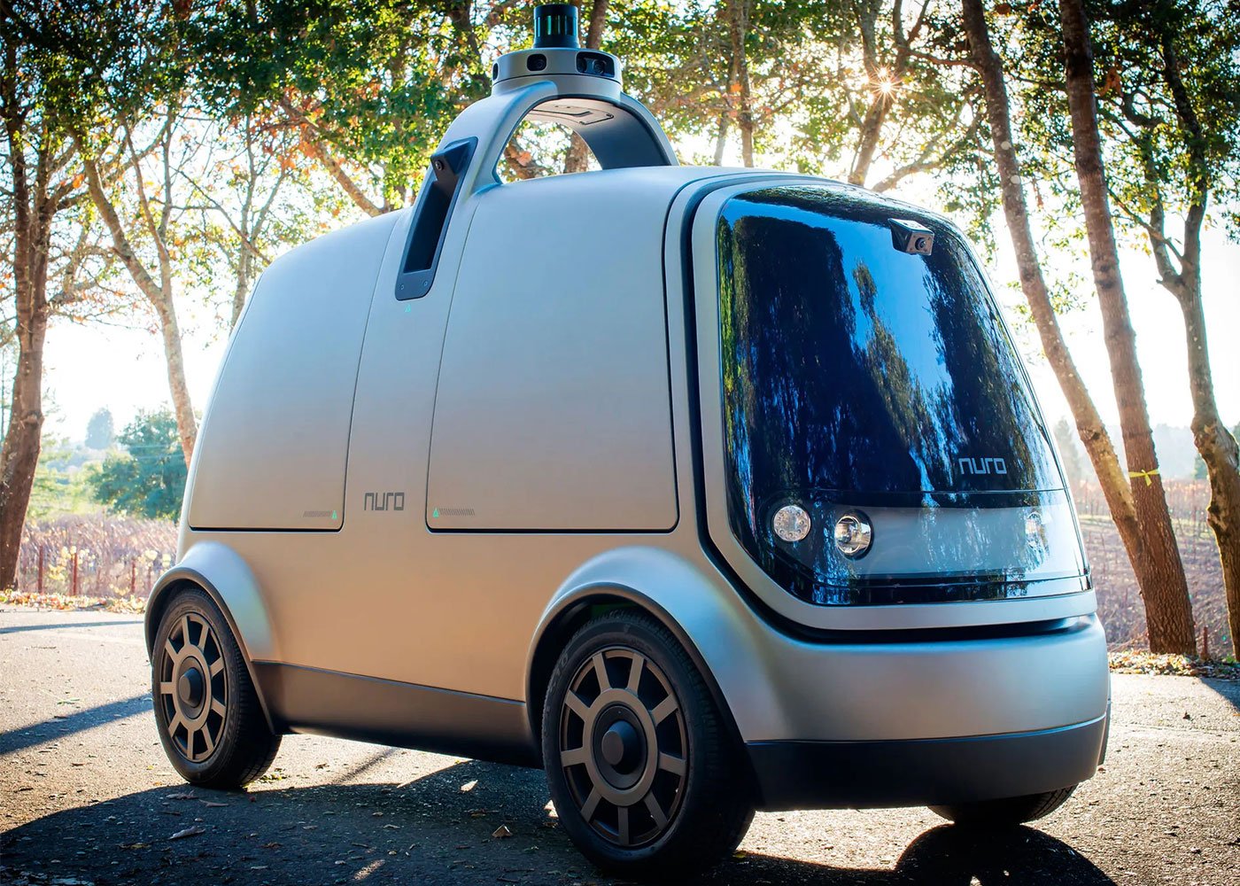 Nuro autonomous vehicle parked on sunlit road.