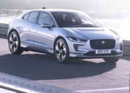Jaguar I-Pace SUV parked by foggy water.