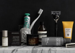 Travel grooming essentials on marble and black backdrop.