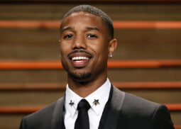 Man in star-collared suit smiling for photo.