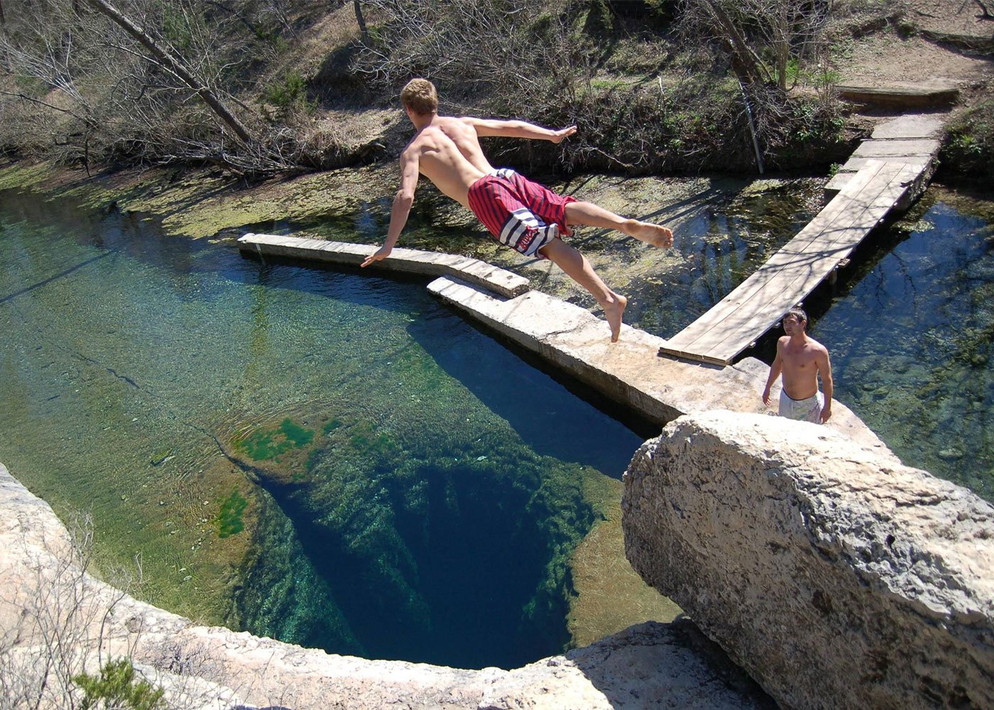 A thrill-seeker jumps at an extreme travel destination.
