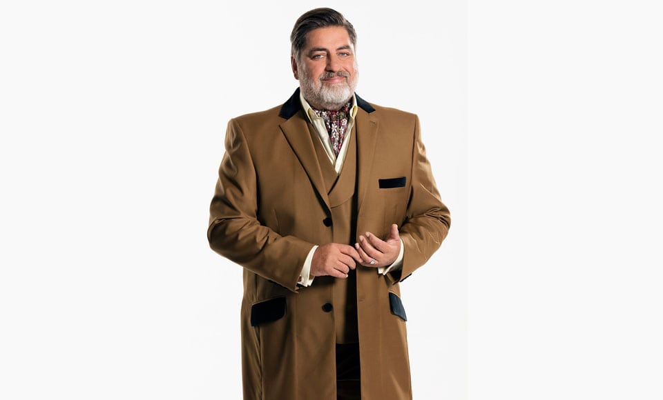 A plus size man wearing a double breasted suit and dress coat. 