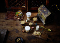 Steaming coffee with pastries and colorful pods.