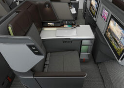 Futuristic airplane business class seats with touchscreens.