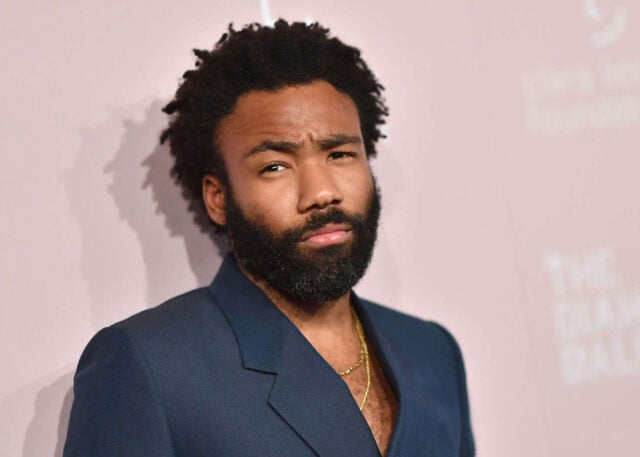 Bearded man in blazer, Glover-like style.