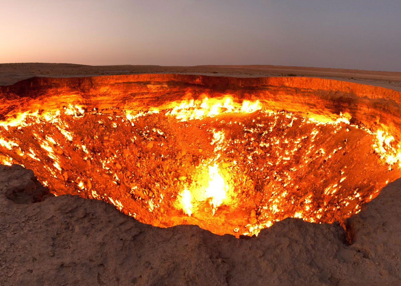 Darvaza gas crater: mesmerizing flames under clear sky.