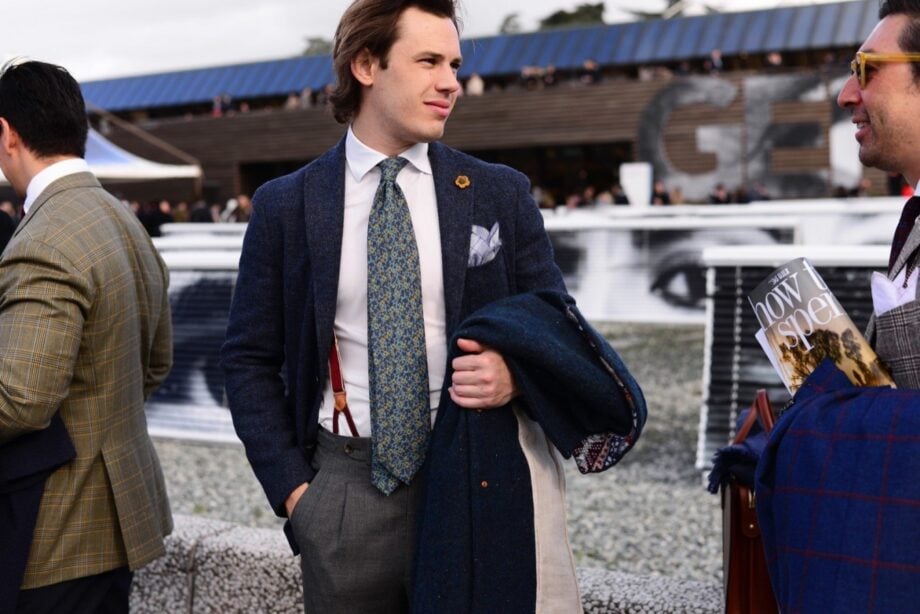 Man in blazer, holding magazine.