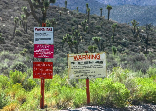 Signs warn: restricted military area, no entry.