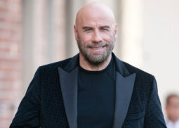A smiling bearded man in black attire.