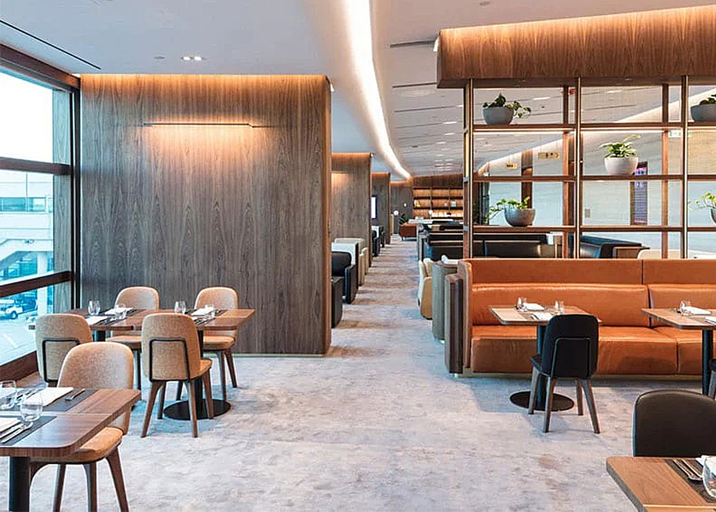 Modern dining area with wood tables and plants.