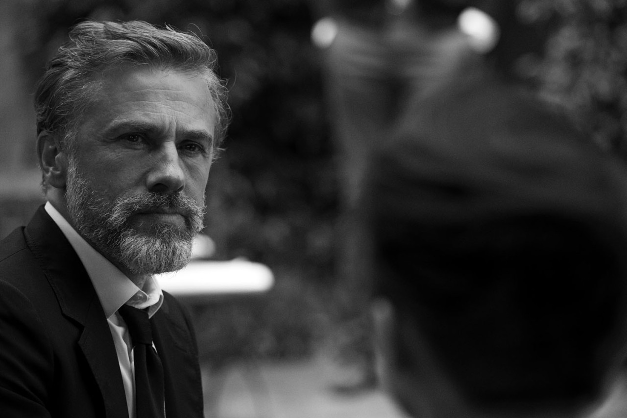 Bearded man in suit, outdoors, black-and-white photo.