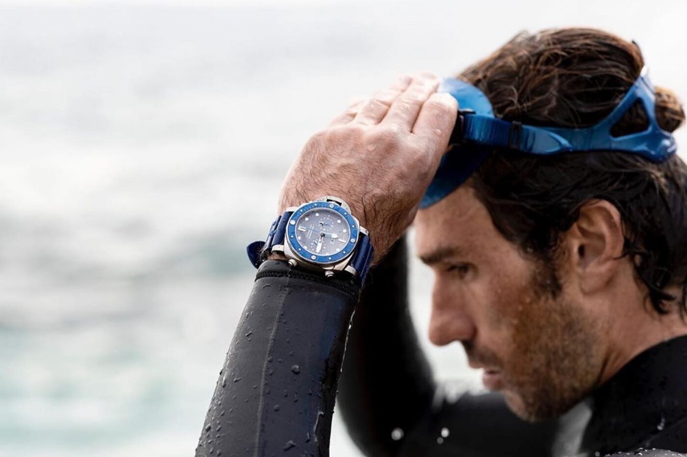 Wetsuit, diving mask, Panerai watch.
