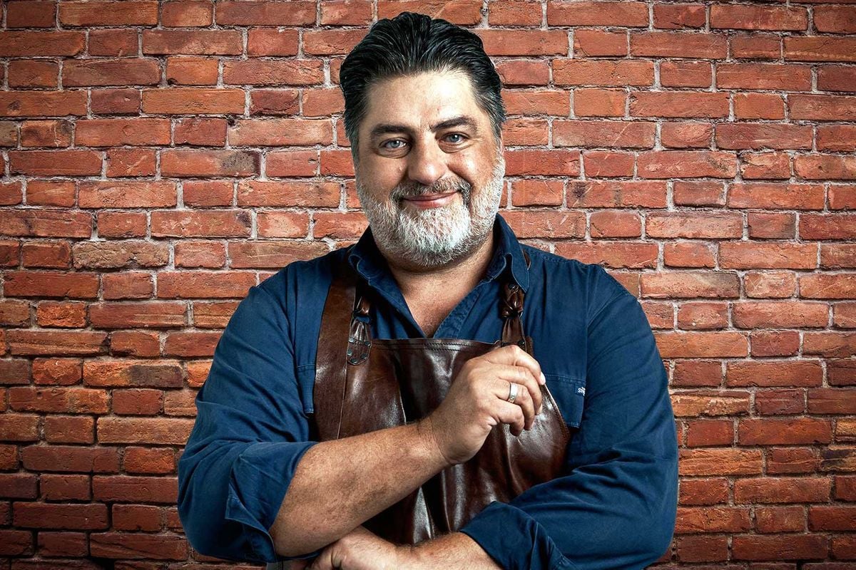 Bearded man poses with spoon, ready to cook.