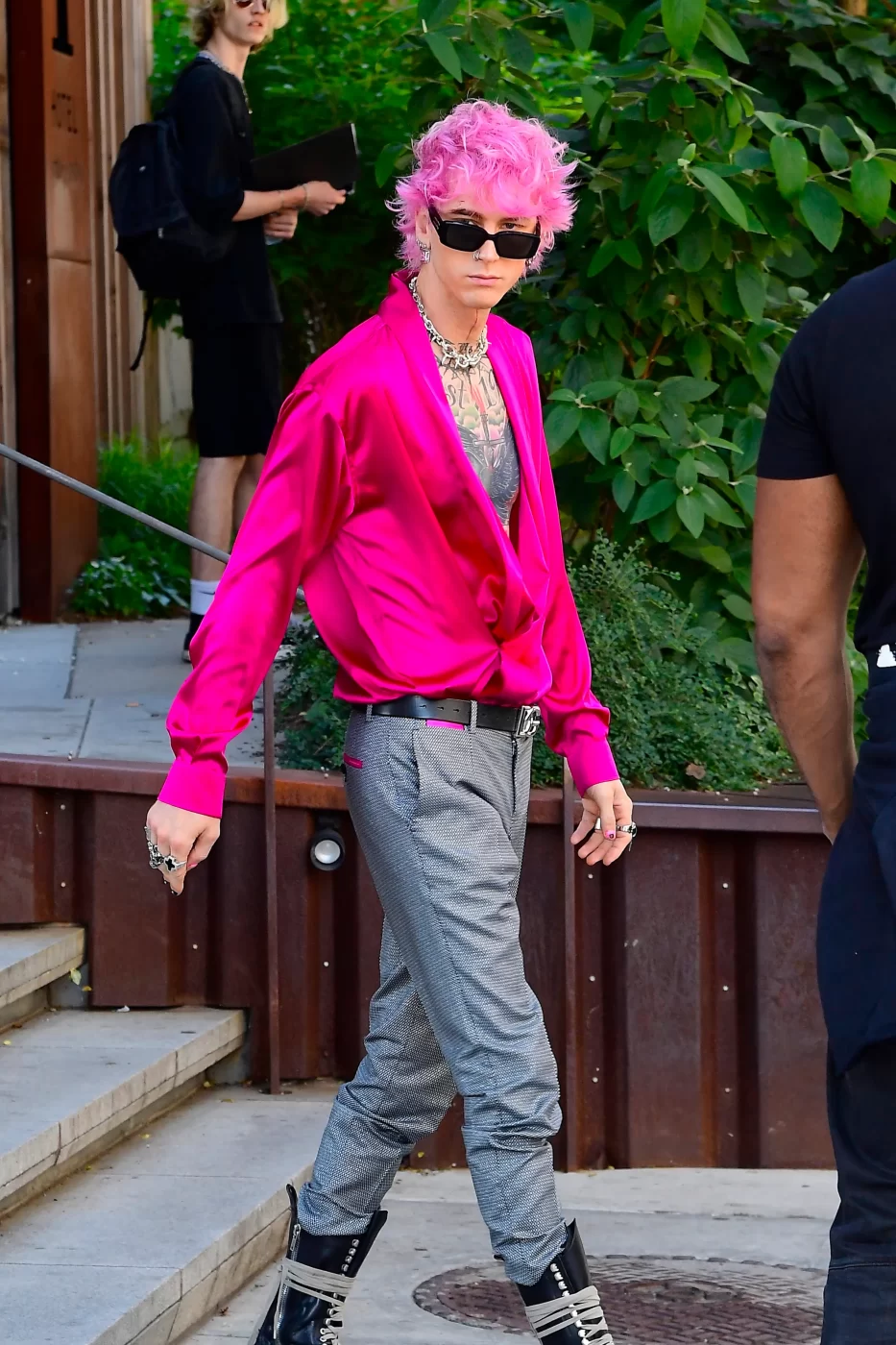 Pink-haired fashionista machine gun kelly in vibrant, modern attire outdoors.