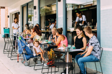 People enjoying a sunny day at Australian café.