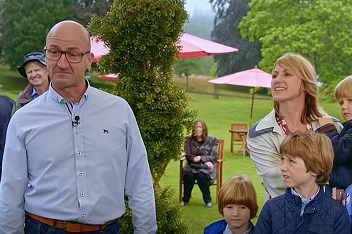 Man with Rolex next to family outdoors.