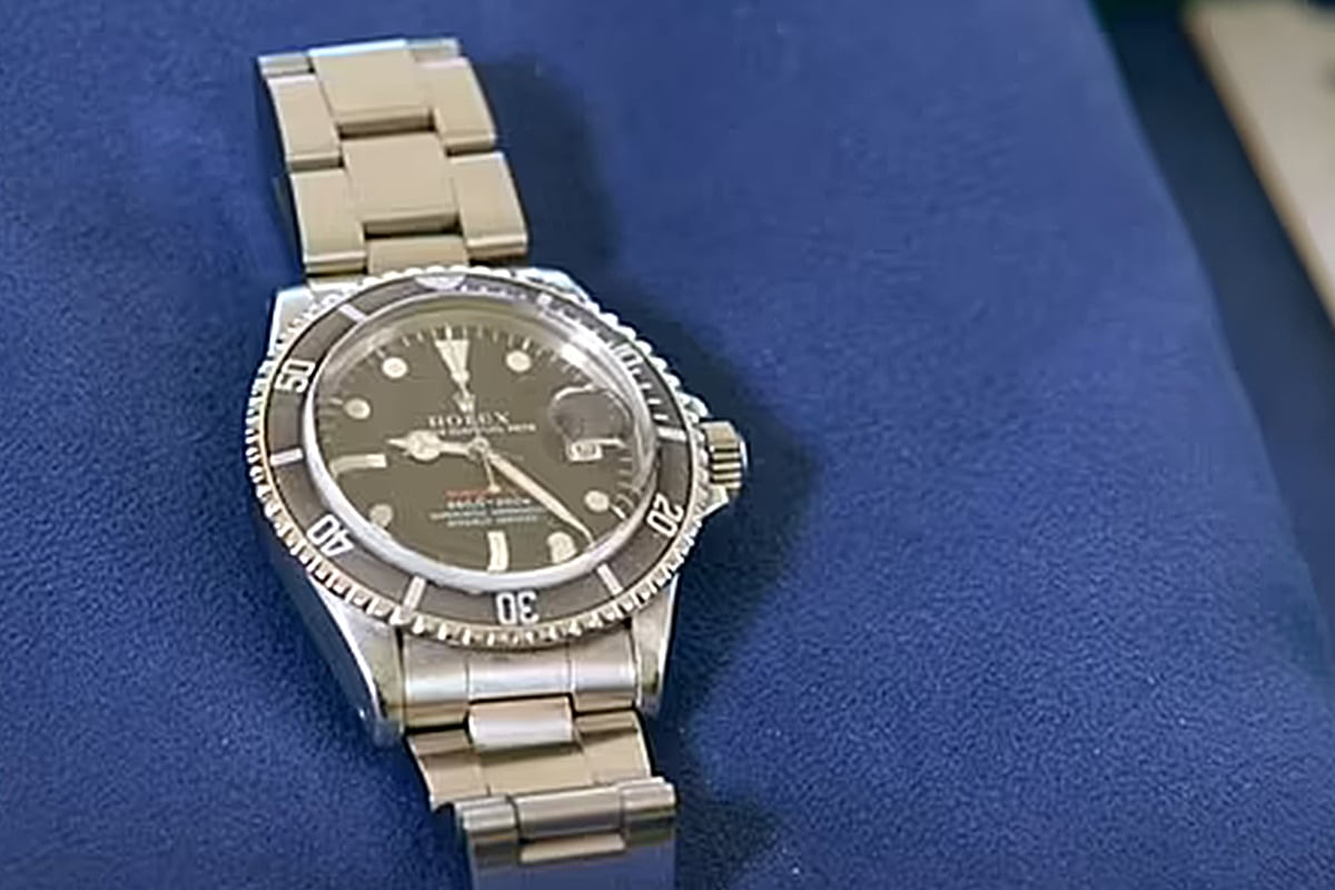 Rolex watch on blue cloth, exudes sophistication.
