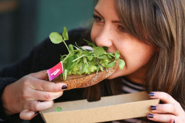 Person enjoys avocado toast inspired by Australian chefs.