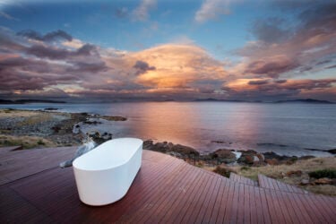 Outdoor bathtub on deck overlooking Australian shoreline.