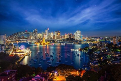 Sydney Harbour Bridge and Opera House illuminate nightlife.