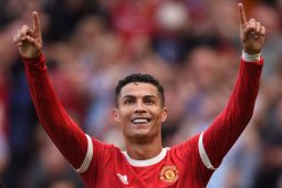 Cristiano Ronaldo celebrates; blurred crowd behind.