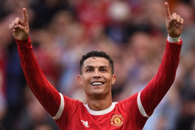 Cristiano Ronaldo celebrates; blurred crowd behind.