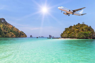 Qantas plane over islands and turquoise sea.