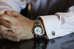 A person wears a Rolex-like silver watch.