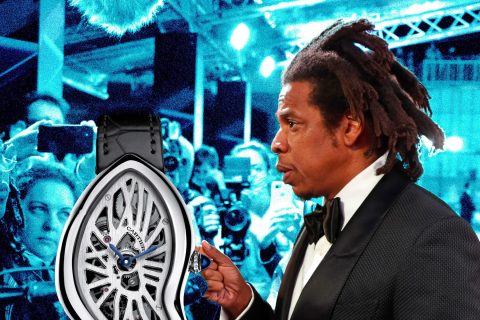 Man in tuxedo displays Cartier watch at event.