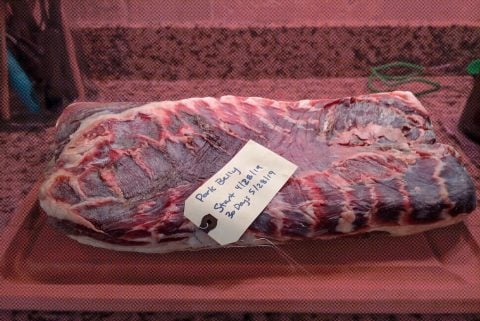 Labeled pork on board near Australian plates.