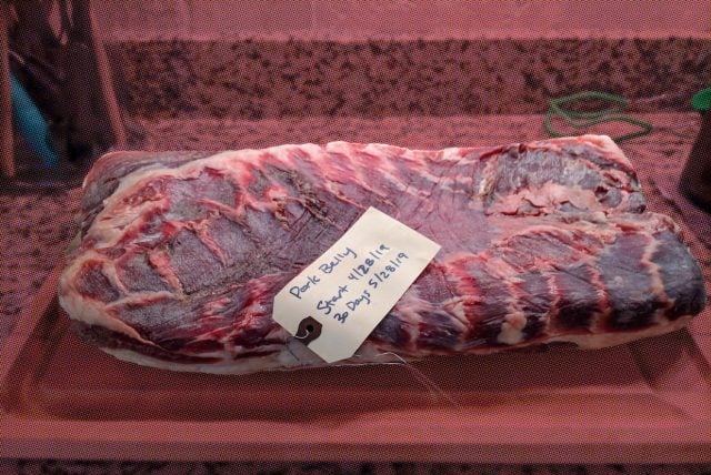 Labeled pork on board near Australian plates.