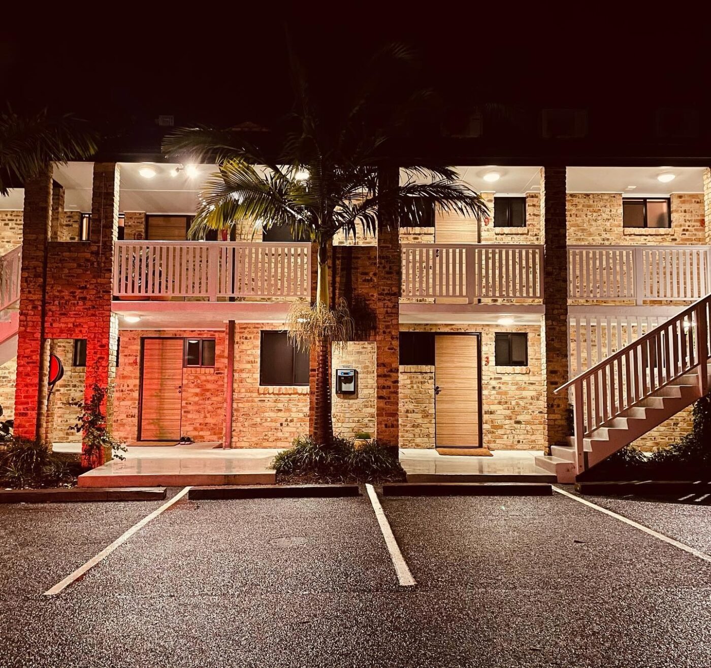 Retro-style motel, Australia: lit balconies and palm fronds.