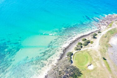Crescent Head: turquoise coast, rocky shore, serene waves.