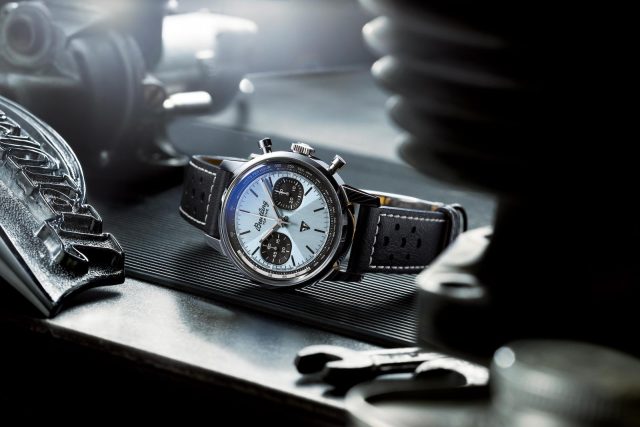 Breitling watch with dial, leather strap, tools.