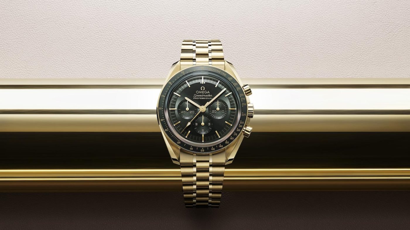 OMEGA Speedmaster: Gold watch with dark face.