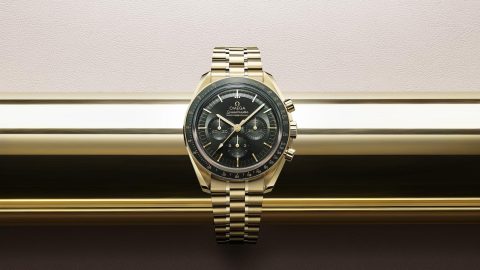 OMEGA Speedmaster: Gold watch with dark face.