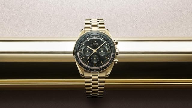OMEGA Speedmaster: Gold watch with dark face.