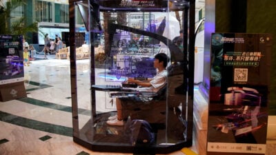 Person plays "Nights of Valor" in glass booth.