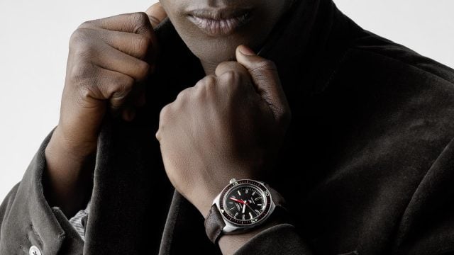 Person showcases Longines watch with black strap.