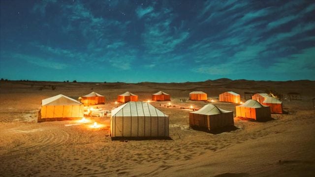 Desert tents in Qatar under serene night sky.