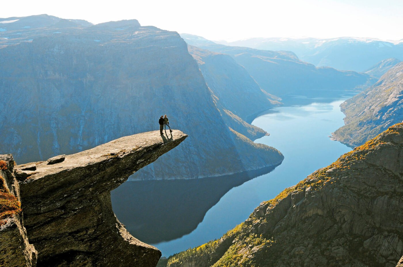 Two friends overlook a stunning fjord landscape.