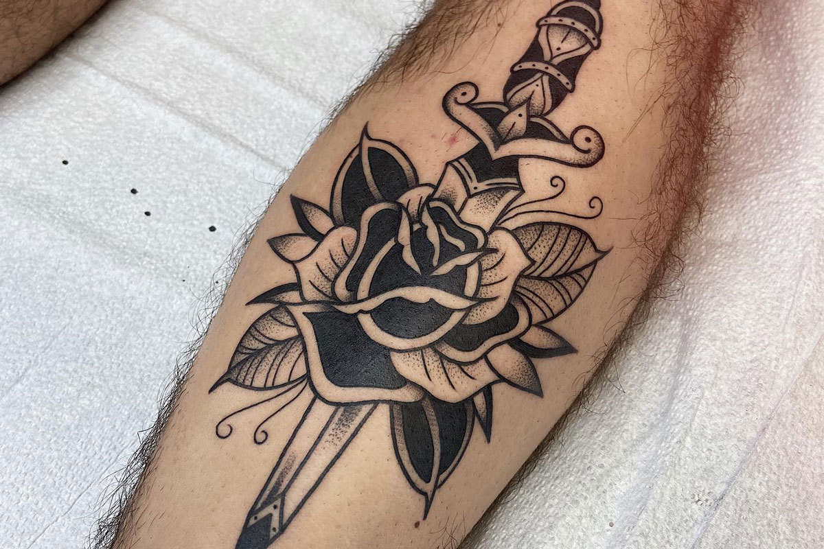 Fine line rose tattoo on the left inner forearm
